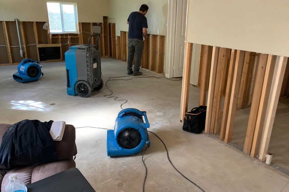 Air movers and dehumidifier drying a stripped-out basement