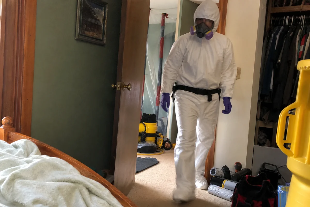 Biohazard technician in full PPE entering a scene