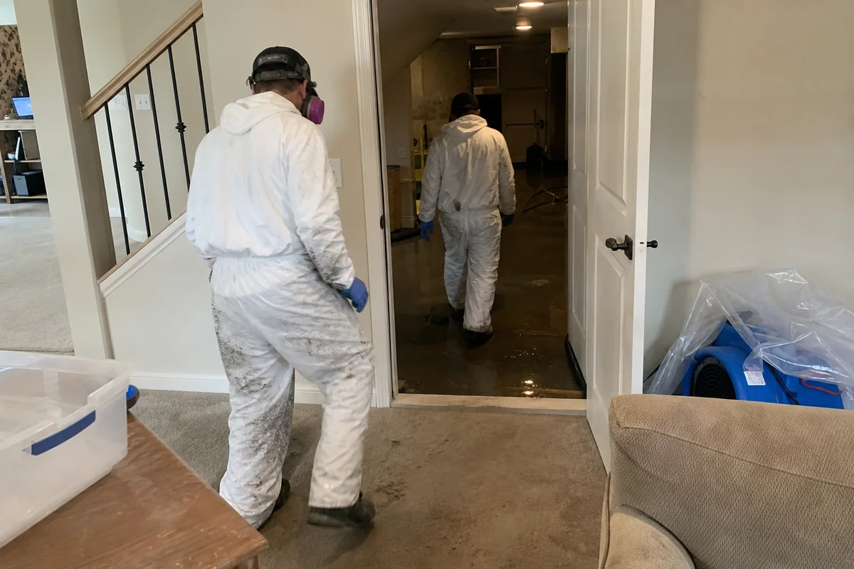 Restoration crew in full PPE entering a contaminated area