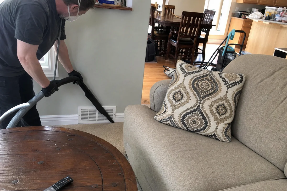 Technician HEPA-vacuuming ash indoors