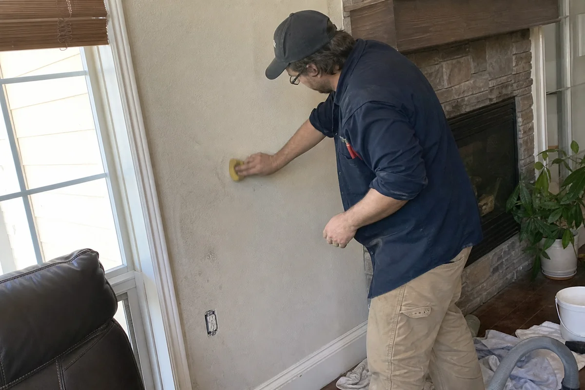 Technician using dry chem sponge on painted wall