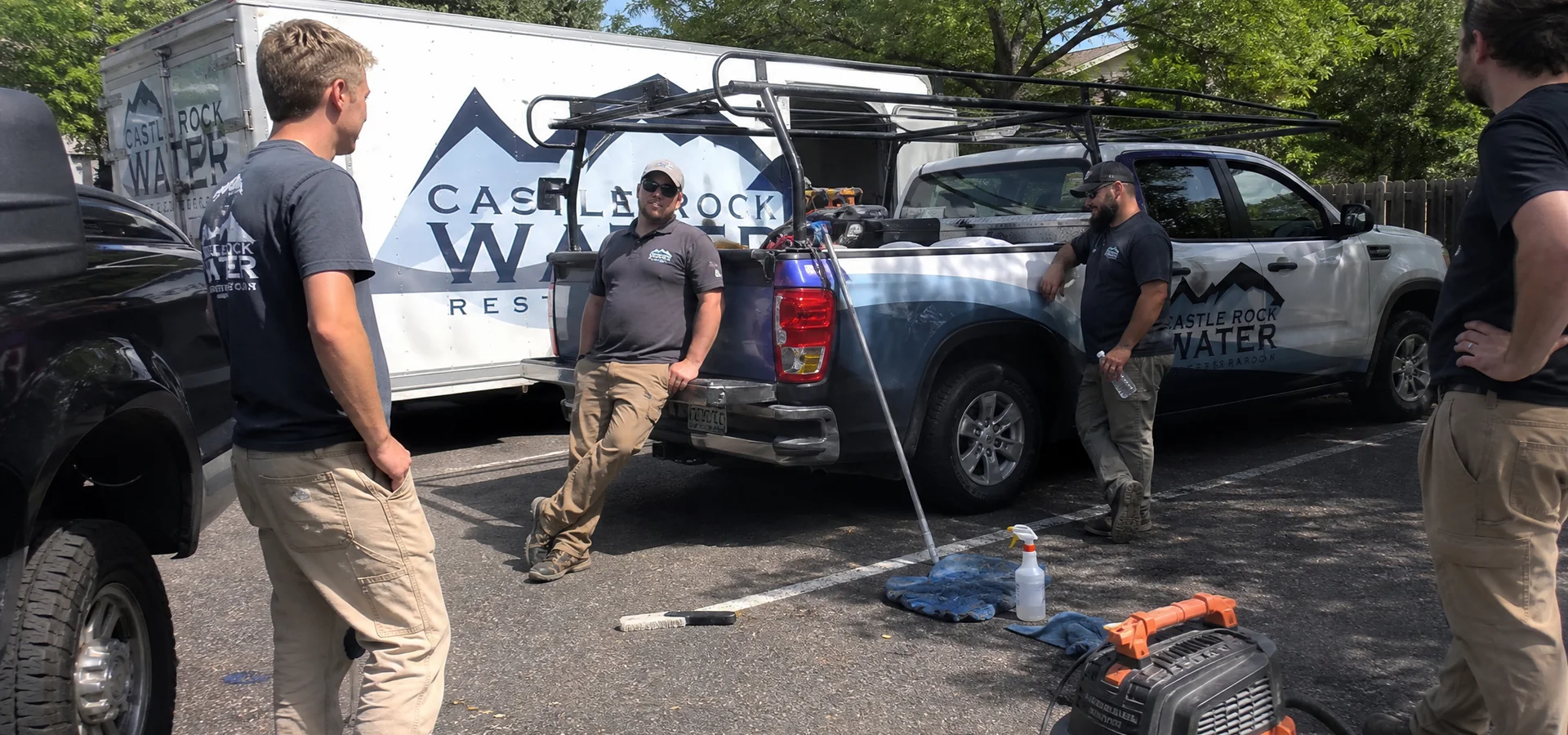 Team standing in front of branded work trucks
