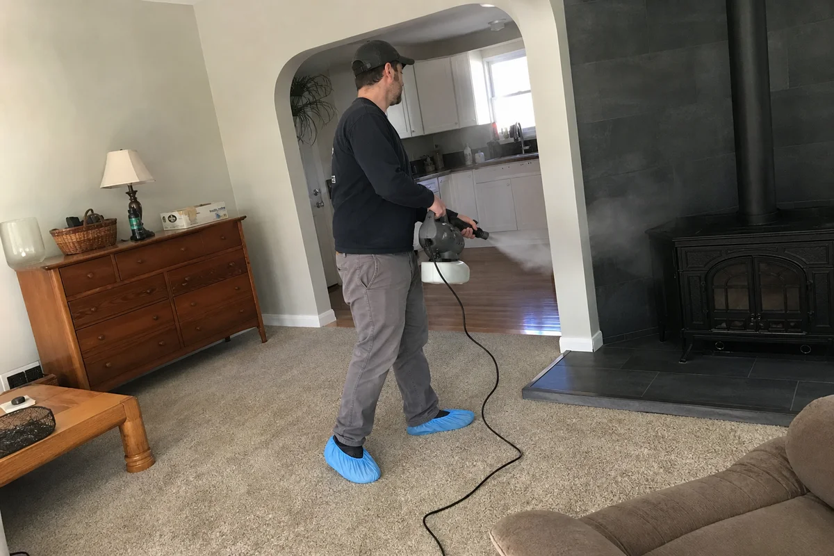 Technician thermal fogging a smoke-damaged room